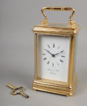 A brass carriage clock by Thwaites & Reed England in original carry case. Damage to case, lid no