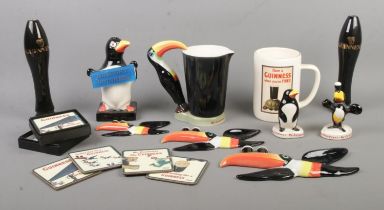 A collection of Guinness advertising items, to include wall plaques, lamp base and place mats.