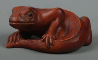 A hand carved hardwood netsuke of a lizard, signed to base.