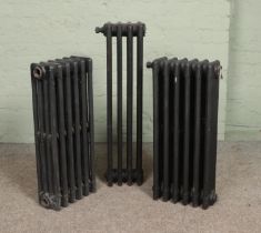 Three painted cast iron radiators. Includes two six bar and one four bar example.