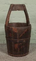 An antique wooden well bucket, with metal mounts. 62cm tall.