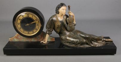 A large Art Nouveau style slate figural mantel clock. Formed as a seated maiden holding a violin. (