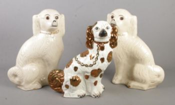 A pair of Victorian mantel dogs along with one similar.