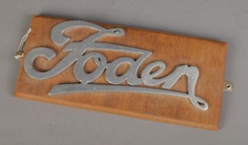 A metal Foden lorry sign mounted on wooden plaque. Approx. size 36cm x 16cm.