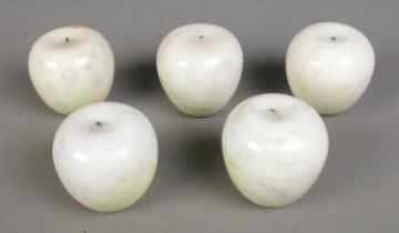 A collection of five white marble apples. Missing stems