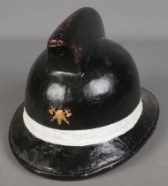 A painted leather fireman's helmet baring axe & helmet insignia.