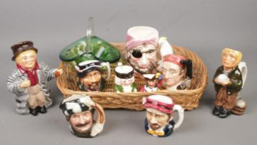 A tray of ceramic character jugs and a green glass basket. Includes Royal Doulton Trapper D6612