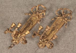 A pair of gilt wall sconces decorated with ribbons and floral motifs.