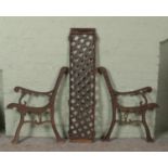 A pair of wrought iron bench ends, along with a iron back panel.