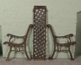 A pair of wrought iron bench ends, along with a iron back panel.