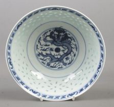 A Chinese blue and white rice bowl. Decorated in underglaze blue with a dragon and bearing character