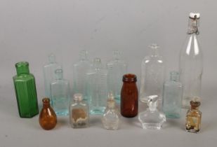 A collection of assorted vintage glass bottles to include several chemists examples.