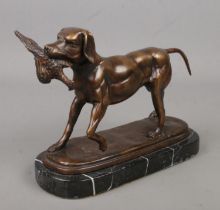 A small bronze sculpture of a hunting dog with game bird in mouth, raised on marble base. Height