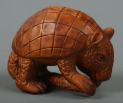 A hand carved hardwood netsuke of a pangolin, signed to base.