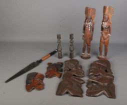 A collection of tribal woodenwares, to include face wall plaques, candlesticks and figures.