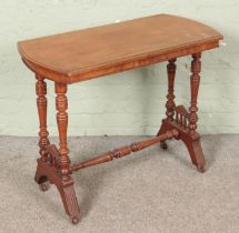 A Victorian mahogany centre table raised on turned tapering column supports and castors on shaped