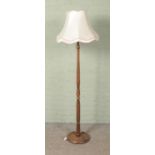 A turned wooden standard lamp with shade.