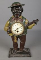 A painted cast iron novelty figural mantel clock formed as a gentleman playing the banjo. Possibly