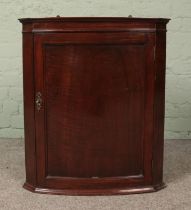 A carved mahogany wall hanging corner cupboard.