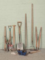 A quantity of wooden handle garden tools, including rake, hoe, shears and shovel, together with a