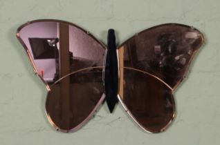 A vintage butterfly wall mirror, with peach and blue class panels. Mounted on wooden back. Width: