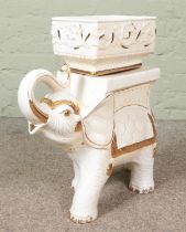 A white and gilt pottery plant stand in the form of an elephant. Height 53cm.