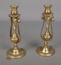 A pair of brass candlesticks, standing or wall mounted with weighted gimble base. One screw
