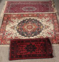 Three rugs. Includes red ground wool runner with central medallion motif, etc.