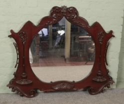 A large carved mahogany over mantel mirror. 104cm x 129cm.