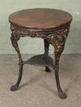 A cast iron based pub table featuring Britannia and lion mask design with wooden circular top.