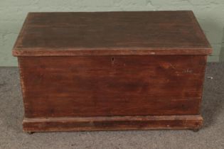 A vintage stained pine blanket box with twin handles and inner candle box on later castors Hx48cm