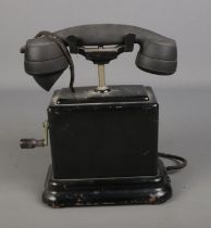 A 1930's hand crank desk phone with bakelite phone and metal body.