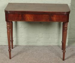 A Victorian mahogany fold over table raised on tapering supports.