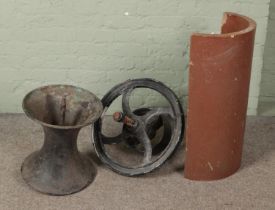 A cast iron diablo style pot together with cast iron wheel and half drainage pipe marked J Kitson