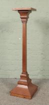 An oak torchere with square top over a plain square column on a stepped base. Hx110cm