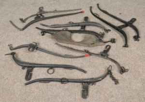 A collection of horse hames along with a wooden yoke featuring two cast iron chains.