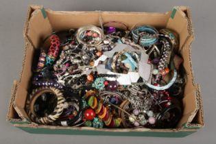 A large box of costume jewellery. Includes bangles and necklaces.