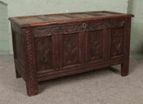 An 18th century carved and pannelled oak coffer. End top piece loose. Signs of woodworm.