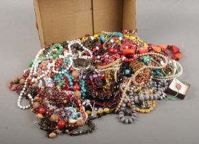 A box of costume jewellery. Includes beads, bangle, earrings, ring etc.