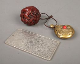 A small collection of Oriental items. Includes Chinese white metal Zodiac ingot, spherical netsuke