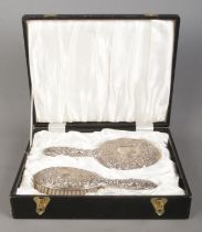 A cased Gents two piece silver filled dressing table set, containing handheld mirror and brush, both