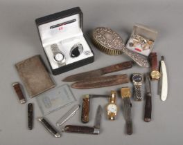 A box of collectables. Includes wristwatches, silver hand brush, pocket knives, silver plate