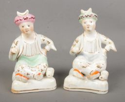 Two 19th century Staffordshire Lloyd Shelton type figures, each modelled as a seated Turk, decorated