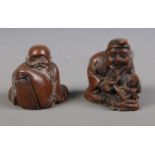 Two Japanese carved hardwood netsukes formed as a gentleman crafting a doll and a gentleman