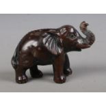 A Japanese carved hardwood Netsuke formed as an Elephant and bearing three character mark to