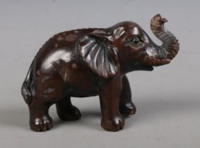 A Japanese carved hardwood Netsuke formed as an Elephant and bearing three character mark to