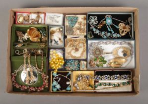 A tray of assorted vintage costume jewellery to include charm bracelet, animal brooches,