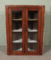 An early 20th stained pine corner cabinet with glazed doors Hx108cm Wx79cm