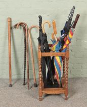 An oak barley twist four section stick stand, with drip tray and a selection of walking sticks and