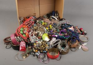 A large box of costume jewellery. Includes bangles and necklaces.